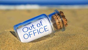 Durchsichtige Flasche am Strand Aufschrift out of office